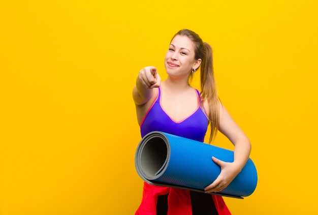 Jonge blonde vrouw met een yogamat. sport concept