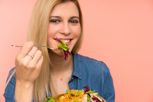 Jonge blonde vrouw met salade