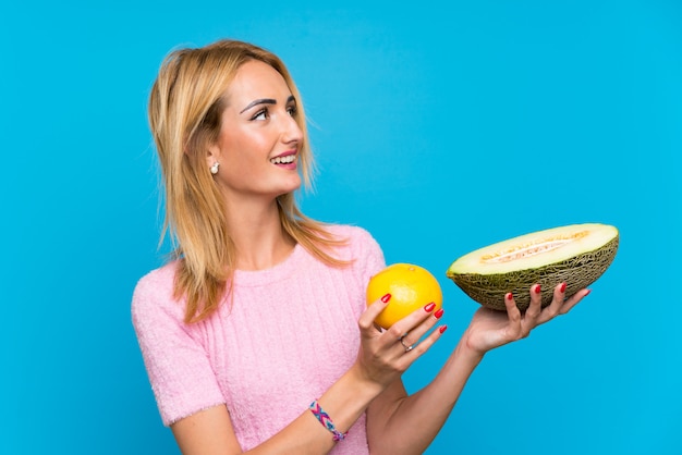 Jonge blonde vrouw met vruchten