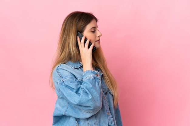 Jonge blonde vrouw over het houden van een gesprek met de mobiele telefoon met iemand