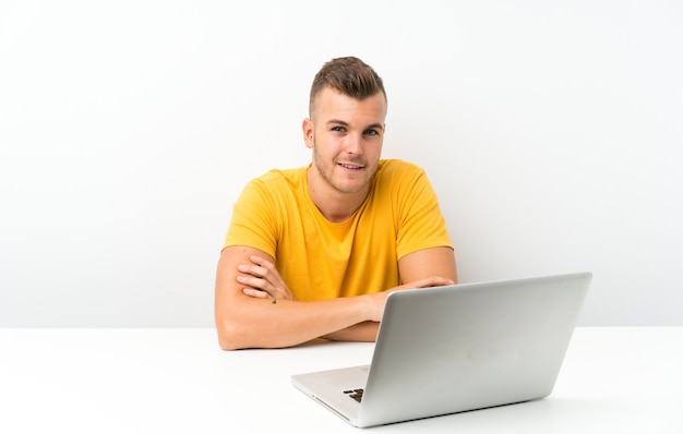 Jonge blondeman in een tafel met een laptop