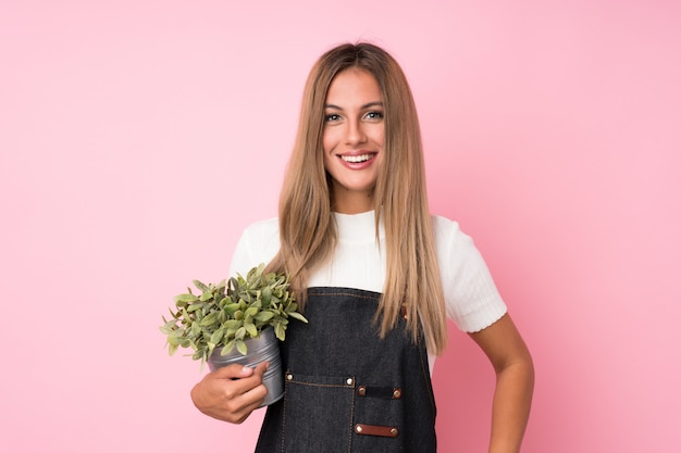 Jonge blondevrouw die een bloempot nemen