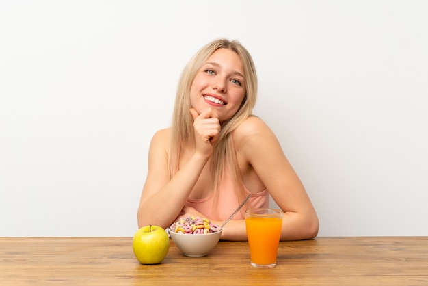 Jonge blondevrouw die ontbijt het lachen hebben