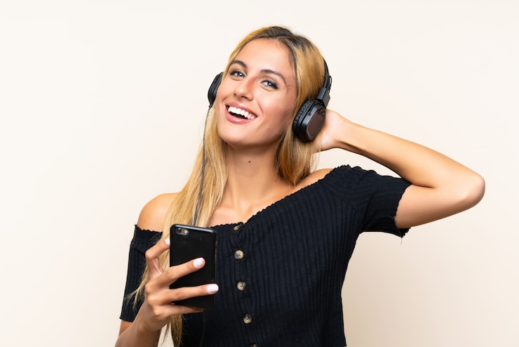Foto jonge blondevrouw het luisteren muziek met mobiel
