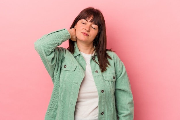 Jonge bochtige blanke vrouw geïsoleerd op roze achtergrond met nekpijn als gevolg van stress, masseren en aanraken met de hand.