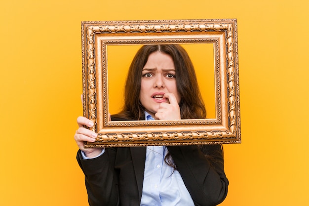 Jonge bochtige plus size zakenvrouw met een frame bijtende nagels, nerveus en erg angstig.