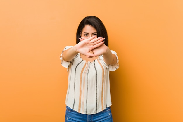 Jonge bochtige vrouw die een ontkenningsgebaar doet