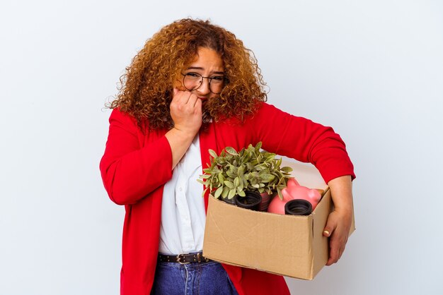 Jonge bochtige vrouw verhuizen naar een nieuw huis op een witte achtergrond vingernagels bijten, nerveus en erg angstig.