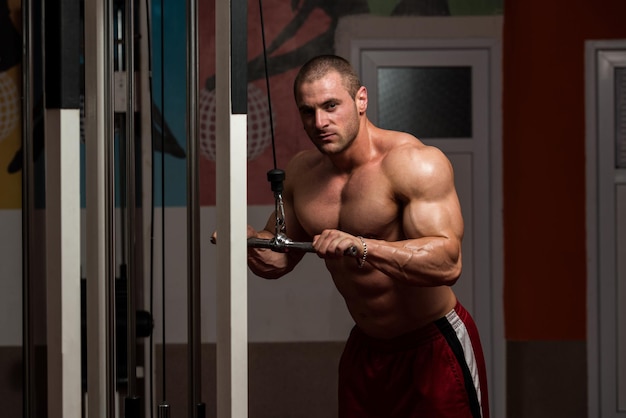 Jonge bodybuilder doet zware oefening voor triceps