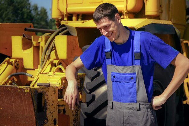 Jonge boer lacht op de achtergrond van de tractor