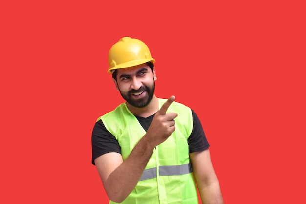 jonge bouwvakker glimlachend en wijzend naar het juiste Indiase Pakistaanse model
