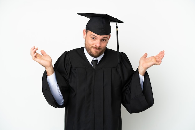 Jonge Braziliaanse afgestudeerde universiteit geïsoleerd op een witte achtergrond die twijfels heeft terwijl hij zijn handen opsteekt