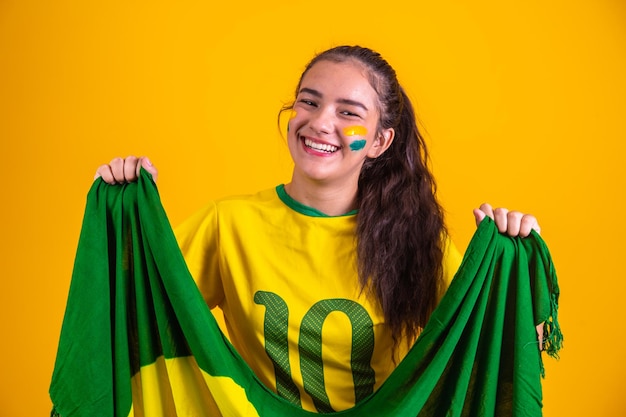 Jonge Braziliaanse cheerleader met een Braziliaanse vlag die vrolijk lacht