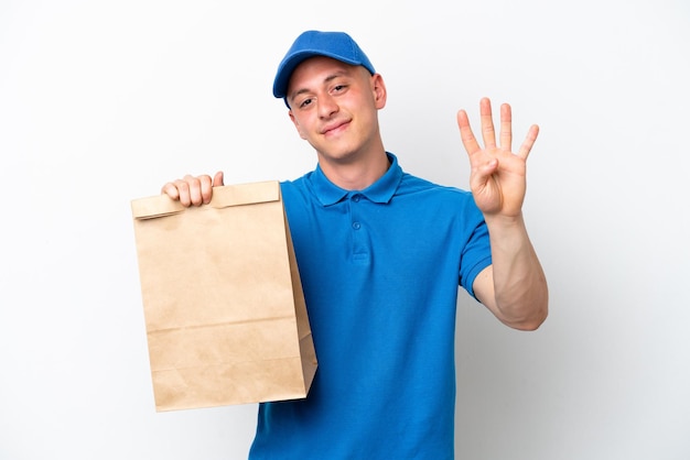Jonge Braziliaanse man die een zak afhaalmaaltijden neemt geïsoleerd op een witte achtergrond gelukkig en vier tellen met vingers