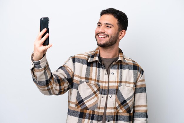 Jonge Braziliaanse man geïsoleerd op een witte achtergrond die een selfie maakt