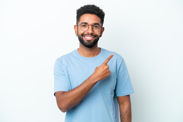 Jonge Braziliaanse man geïsoleerd op een witte achtergrond wijst naar de zijkant om een product te presenteren