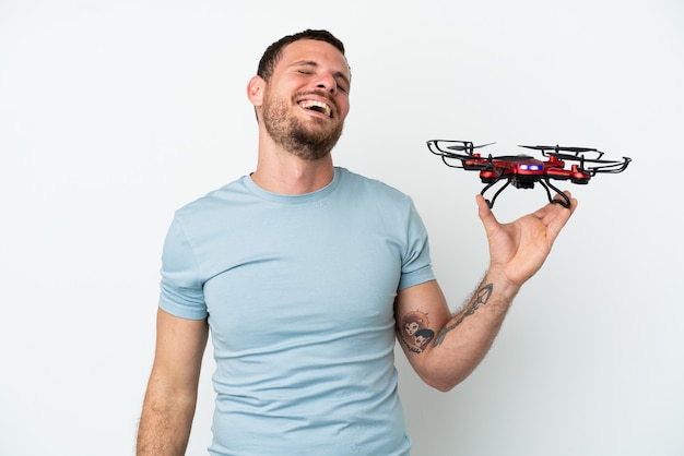 Jonge Braziliaanse man met een drone geïsoleerd op een witte achtergrond lachen