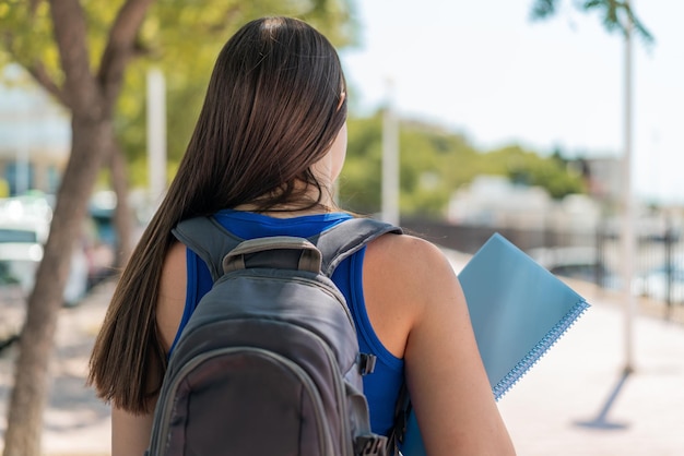 Jonge Braziliaanse studentenvrouw in de buitenlucht in achterpositie