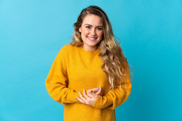 Jonge Braziliaanse vrouw geïsoleerd op blauw lachen