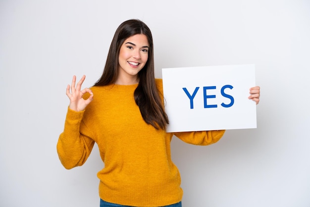 Jonge Braziliaanse vrouw geïsoleerd op een witte achtergrond met een bordje met de tekst YES