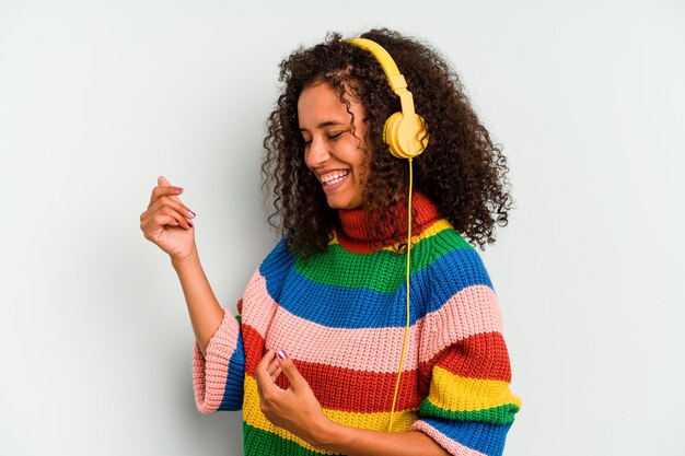 Jonge Braziliaanse vrouw luisteren naar muziek geïsoleerd op blauwe achtergrond