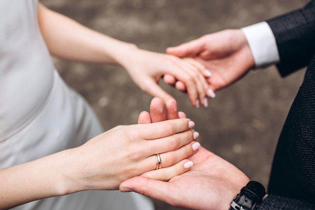 Jonge bruid en bruidegom hand in hand in de tuin