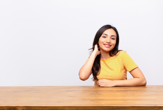 jonge brunette aan een bureau vrolijk lachen