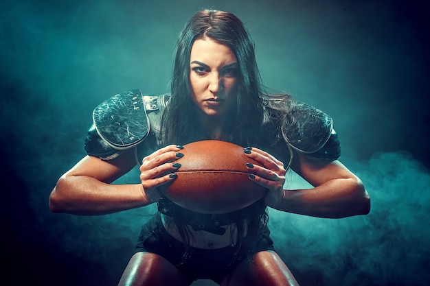 Jonge brunette dragen uniform van rugby football-speler poseren met bal.