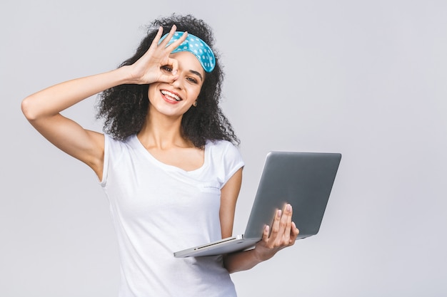 Jonge brunette krullend vrouw met een slaapmasker