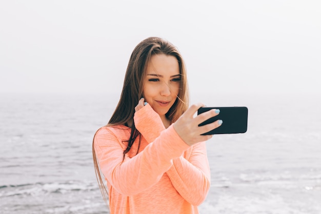 Jonge brunette met lang haar is gefotografeerd op strand