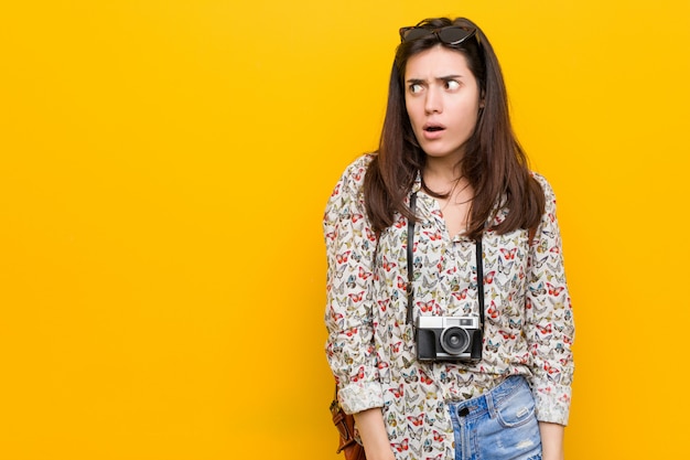 Jonge brunette reiziger vrouw geschokt vanwege iets dat ze heeft gezien.