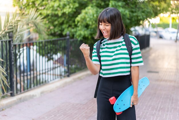 Jonge brunette vrouw buitenshuis met een skate