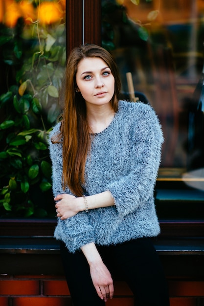 Jonge brunette vrouw poseren voor showcase met reflecties.