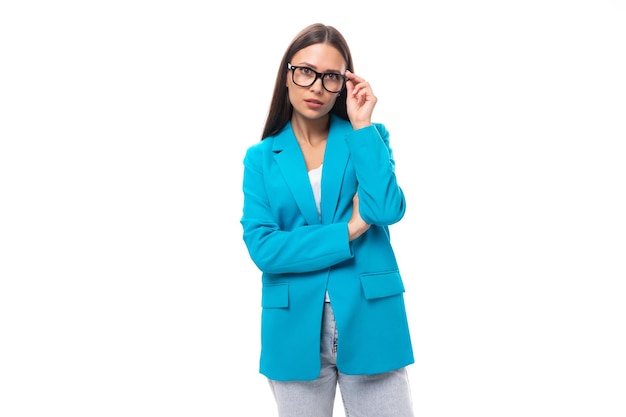 Jonge brunette vrouw secretaresse in een blauwe elegante jas op een witte achtergrond met kopieerruimte