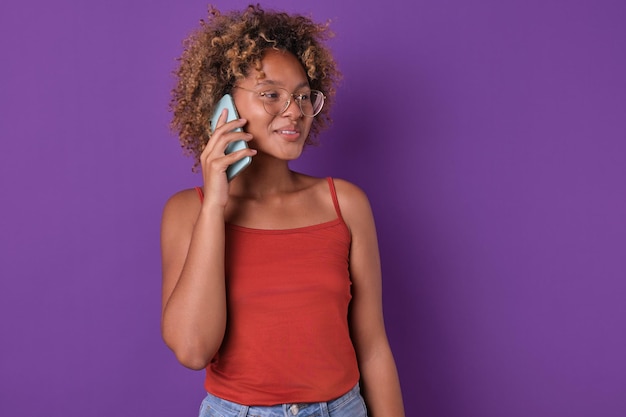 Foto jonge casual afro-amerikaanse vrouw student zet mobiele telefoon aan het oor maken van een telefoontje