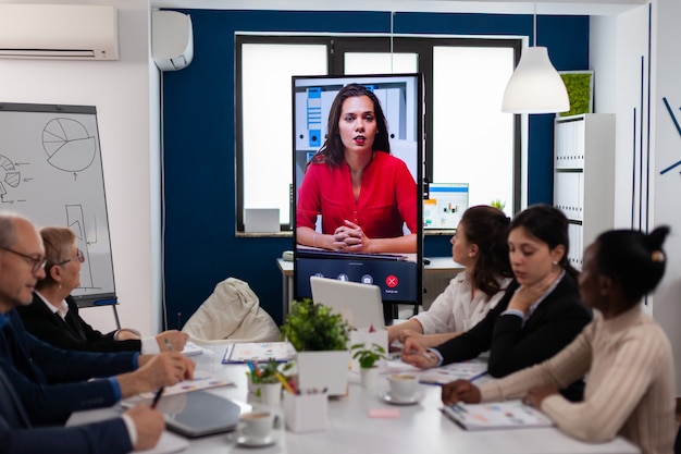 Jonge ceo die tegen de camera spreekt tijdens virtuele zakelijke videopresentatie voor zakenpartners. Mensen uit het bedrijfsleven praten met de webcam, doen aan online conferenties deelnemen aan internetbrainstormen, op afstand werken