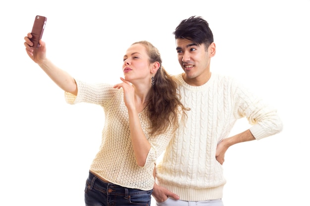 Jonge charmante vrouw met jonge knappe man met donker haar in truien en jeans die selfie maken