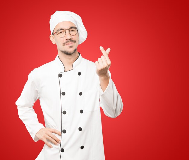 Jonge chef-kok die een gebaar maakt van ongerust gemaakt over zijn economie