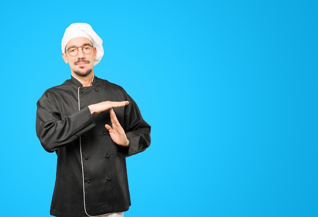 jonge chef-kok een time-out gebaar maken met zijn handen