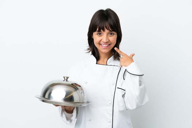 Jonge chef-kok met dienblad geïsoleerd op een witte achtergrond met een duim omhoog gebaar