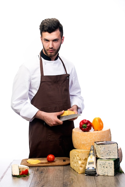 Jonge chef-kok met kazen geïsoleerd op een witte muur, kaasreclame