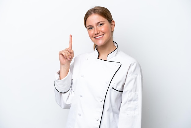 Jonge chef-kokvrouw die op witte achtergrond wordt geïsoleerd die een vinger toont en opheft in teken van de best