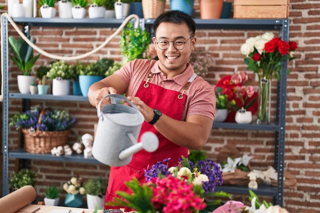 Jonge chinese man bloemist drenken plant bij bloemist