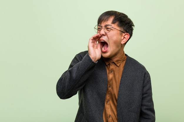 Jonge Chinese man tegen een groene muur