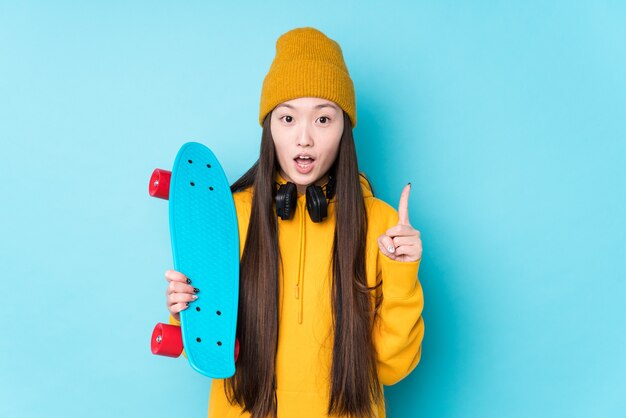 Jonge chinese skater vrouw geïsoleerd met een geweldig idee, concept van creativiteit.