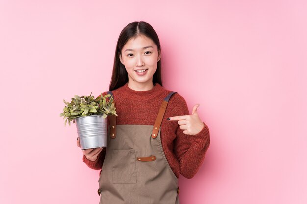 Jonge Chinese tuinmanvrouw die een installatie houden richtend aan zich, trots en zeker