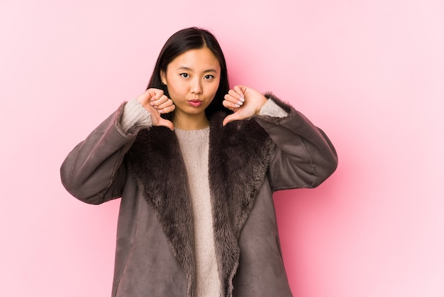 Jonge chinese vrouw die een geïsoleerde jas draagt, voelt zich trots en zelfverzekerd, voorbeeld om te volgen.