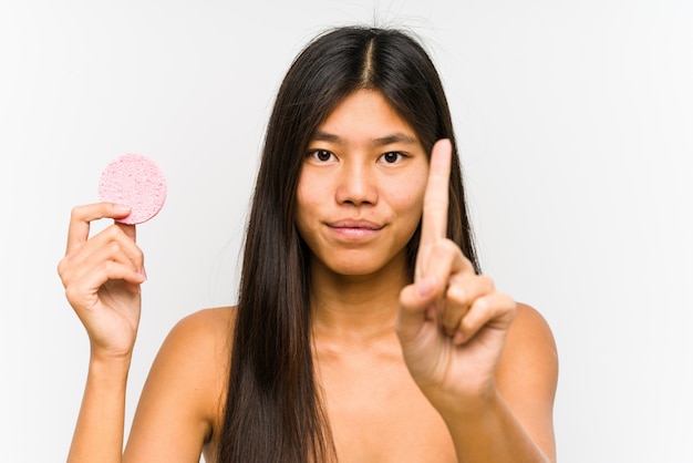 Jonge Chinese vrouw die een gezichtsschijf geïsoleerd houdt tonend nummer één met vinger.