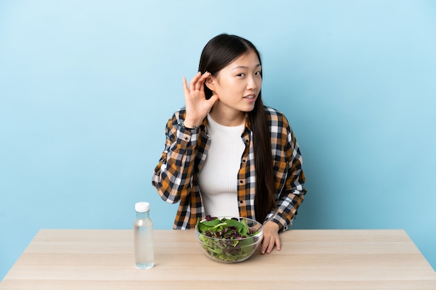 Jonge Chinese vrouw die een salade eet