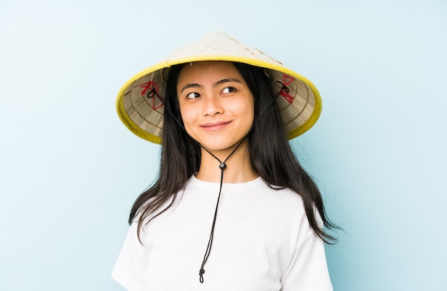 Foto jonge chinese vrouw die een vietnamees verrast en geschokt hooi draagt.